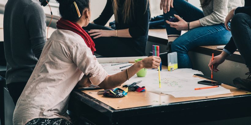 Groupe d'étudiants assis autour d'une table en train de travailler