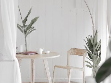 pièce en parquet clair avec table et chaise blanches et luminaire design