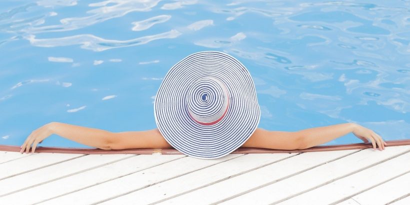 piscine avec une femme dedans avec un chapeau sur la tête